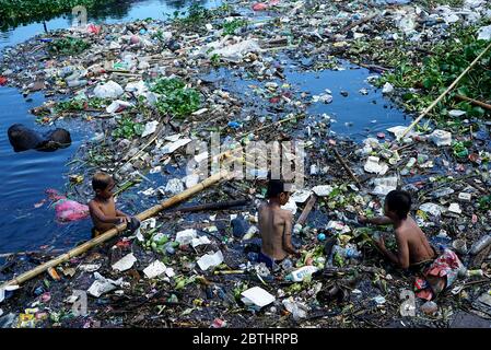 Makassar, Indonesien. Mai 2020. Kinder sammeln Plastikflaschen in einem Fluss, der mit Müll gefüllt ist, in der Slumgegend von Makassar City, South Sulawesi, Indonesien, 26. Mai 2020.mit der andauern der weltweiten Pandemie steigt die Menge an Plastikmüll an und es besteht ein hohes Risiko, weggeworfene medizinische Geräte, die bei Coronavirus-Patienten verwendet werden, zu übertragen. (Foto: Ali Fahmi/INA Photo Agency/Sipa USA) Quelle: SIPA USA/Alamy Live News Stockfoto