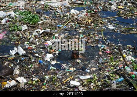 Makassar, Indonesien. Mai 2020. Ein Junge schwimmt in einem Fluss voller Müll im Slum, Makassar City, South Sulawesi, Indonesien, 26. Mai 2020.während die weltweite Pandemie andauert, steigt die Menge an Plastikmüll an und es besteht ein hohes Risiko, weggeworfene medizinische Geräte, die bei Coronavirus-Patienten verwendet werden, zu übertragen. (Foto: Ali Fahmi/INA Photo Agency/Sipa USA) Quelle: SIPA USA/Alamy Live News Stockfoto