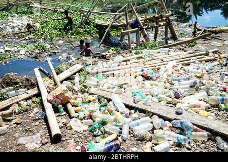 Makassar, Indonesien. Mai 2020. Kinder sammeln Plastikflaschen in einem Fluss, der mit Müll gefüllt ist, in der Slumgegend von Makassar City, South Sulawesi, Indonesien, 26. Mai 2020.mit der andauern der weltweiten Pandemie steigt die Menge an Plastikmüll an und es besteht ein hohes Risiko, weggeworfene medizinische Geräte, die bei Coronavirus-Patienten verwendet werden, zu übertragen. (Foto: Ali Fahmi/INA Photo Agency/Sipa USA) Quelle: SIPA USA/Alamy Live News Stockfoto