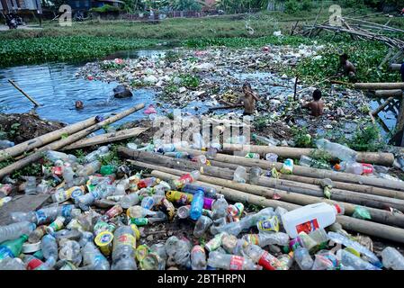 Makassar, Indonesien. Mai 2020. Kinder sammeln Plastikflaschen in einem Fluss, der mit Müll gefüllt ist, in der Slumgegend von Makassar City, South Sulawesi, Indonesien, 26. Mai 2020.mit der andauern der weltweiten Pandemie steigt die Menge an Plastikmüll an und es besteht ein hohes Risiko, weggeworfene medizinische Geräte, die bei Coronavirus-Patienten verwendet werden, zu übertragen. (Foto: Ali Fahmi/INA Photo Agency/Sipa USA) Quelle: SIPA USA/Alamy Live News Stockfoto