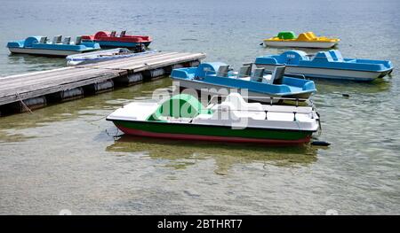 Utting, Deutschland. Mai 2020. Bunte Tretboote liegen an einem Steg am Ammersee. Kredit: Sven Hoppe/dpa/Alamy Live News Stockfoto