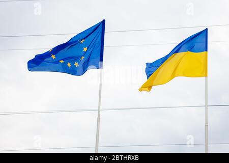 Die Flagge der Europäischen Union und der Ukraine flattert auf dem Fahnenmast. Flaggen Europas. Stockfoto