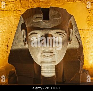 Große Statue Kopf von Ramses II pharao im alten ägyptischen Luxor Tempel beleuchtet in der Nacht Stockfoto