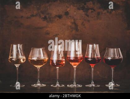 Schattierungen von Roséwein in Gläsern, rostiger Hintergrund, Kopierraum Stockfoto