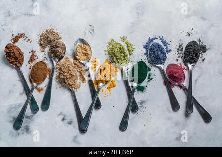 Super Pulver in Löffel - Matcha, Kurkuma, Ingwer, Kakao, Spirulina, Chia, Zimt, schwarzer Sesam Stockfoto