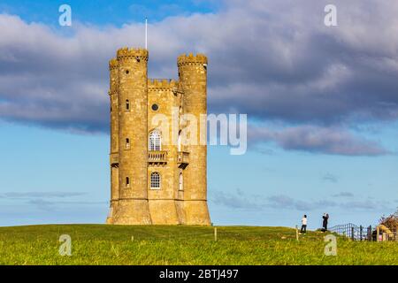 Ein Tourist, der ein Handyfoto vom Broadway Tower auf dem Gipfel des Broadway Hill, Cotswolds, England, macht Stockfoto