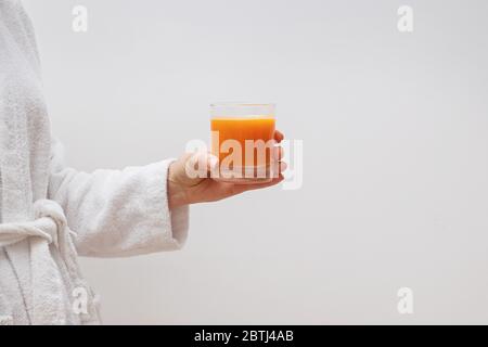 Nahaufnahme der Hand einer Frau, die ein Glas frischen Zitrusfrucht hält Stockfoto