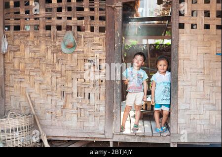 Zwei Kinder vor der Tür ihres Hauses, Nord-Laos, Südostasien Stockfoto