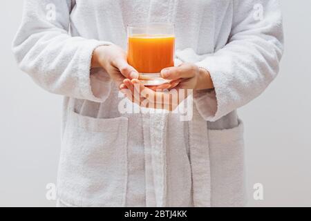 Nahaufnahme der Hände der Frau, die ein Glas frischen Zitrusfrucht halten Stockfoto