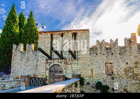 Brescia, Italien, 11. September 2019: Steinmauer mit Meerlonen und Zugbrücke Tor des mittelalterlichen Schlosses Castello oder Falcon von Italien, historisches Stadtzentrum, blauer Wolkenhimmel Hintergrund, Lombardei Stockfoto