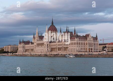 Das Parlament von Budapest beleuchtet bei Sonnenuntergang von einer Bootsfahrt auf der Donau Stockfoto