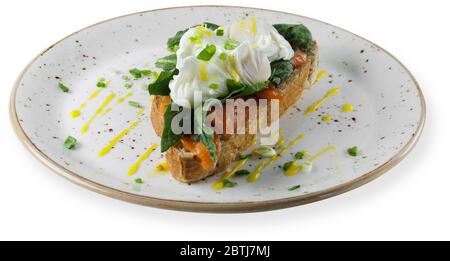 Bruschetta mit pochiertem Ei und geräuchertem Lachs. Weißer Hintergrund. Stockfoto