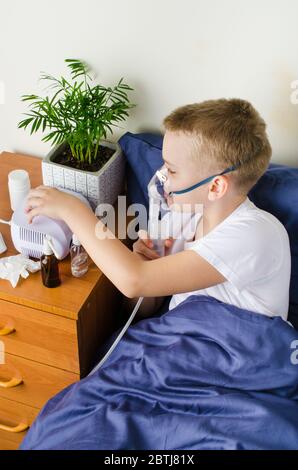 Kranker Junge atmet durch Inhalator Maske. Verwendung von Vernebler und Inhalator für die Behandlung oder die Prävention von Atemwegserkrankungen, wie Coronavirus, Asthma und Stockfoto