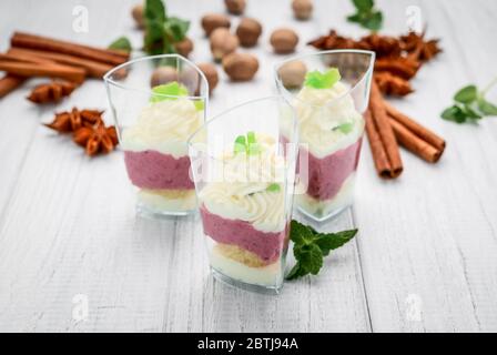 Obstsorbet mit frischen Früchten und Sahne, auf weißem Holzhintergrund Stockfoto