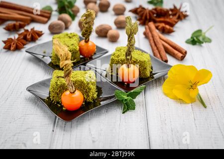 Grüne sizilianische Pistazien-Torte mit Vanille, Mandel und Nüssen Toppings in weißem Hintergrund Stockfoto