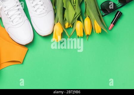 Flache Lay Komposition mit femininen Accessoires und gelben Tulpen Stockfoto