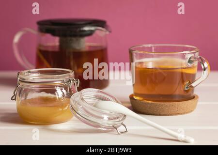 Honig in Glaskanne und Tasse schwarzen Tee mit Zitrone. Gesundes Essen Konzept. Stockfoto