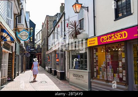 Brighton UK 26. Mai 2020 - EINE Frau geht durch das verlassene berühmte Einkaufsviertel von Brighton, während die Sperrbeschränkungen während der COVID-19 Pandemiekrise andauern. Gestern kündigte Premierminister Boris Johnson an, dass nicht-wesentliche Geschäfte ab dem 15. Juni geöffnet werden können, da die Beschränkungen langsam gelockert werden. Quelle: Simon Dack / Alamy Live News Stockfoto