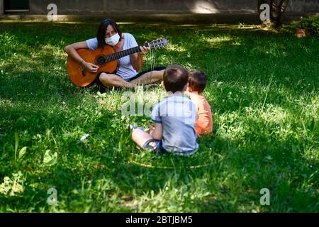 Ivrea, Italien - 26. Mai 2020: Ein Lehrer spielt Gitarre in einem Schulgarten. Die Gemeinde Ivrea eröffnet die Gärten zweier Kindergartenschulen im Rahmen eines Pilottests, um zu sehen, wie die Schulen nach der Sperrung des Coronavirus COVID-19 wieder eröffnet werden können. Quelle: Nicolò Campo/Alamy Live News Stockfoto