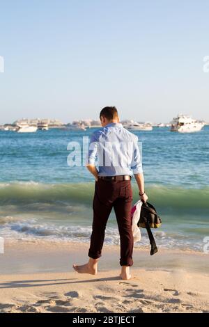 Ein Mann läuft am Strand entlang. Stockfoto