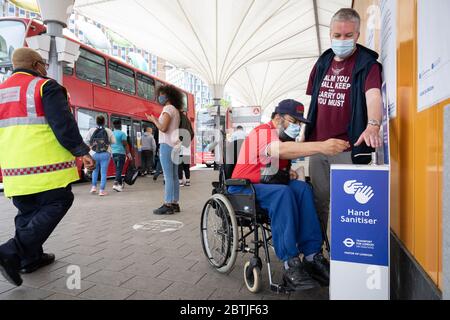 Pendler benutzen einen Handdesinfektionsort am Busbahnhof von Stratford. London, Großbritannien. Mai 2020 Stockfoto