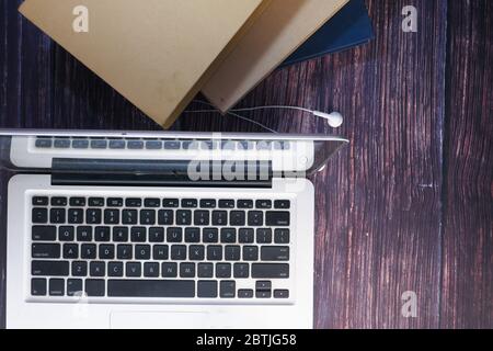 Stapel von Büchern mit Laptop auf Holztisch. Stockfoto