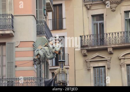 Dragon Statue auf der Ecke der Straße La Rambla Barcelona, mit einem orientalischen Fan darauf. Stockfoto