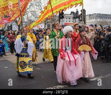 Frauen und Männer in traditioneller chinesischer Kleidung mit Fans und Fahnen. Parade Zur Chinesischen Neujahrsfeier. London Stockfoto