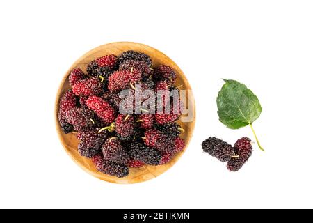 Haufen Maulbeeren in Holzplatte und auf dem Boden mit Blatt auf weißem Hintergrund mit Clipping-Pfad. Stockfoto