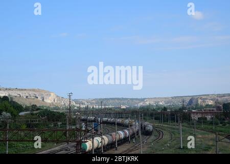 Eine Eisenbahnstrecke führt gegenüber dem alten Steinbruch. Stockfoto