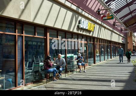 Shopper essen Essen zum Mitnehmen außerhalb eines geschlossenen Subway-Restaurants in den wiedereröffneten Woodburn Premium Outlets am Memorial Day Wochenende inmitten der COVID-19-Pandemie. Stockfoto