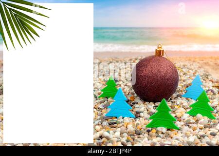 Neujahr am Meer. Neujahrsspielzeug am Strand am Meer in der Heizung von Papier Weihnachtsbäumen. Stockfoto