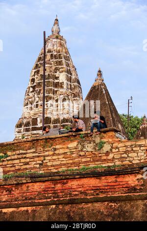 Indien, Varanasi - Bundesstaat Uttar Pradesh, 31. Juli 2013. Am Morgen, neben den Ruinen eines alten Tempels, ruhen sich drei Männer aus und reden. Stockfoto