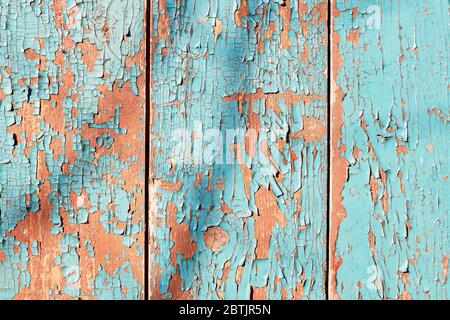 Gealterte vertikale Holztafel Hintergrund mit cyan und orange abblätternden Farbe Textur. Frontale Nahaufnahme mit Baumschatten Stockfoto