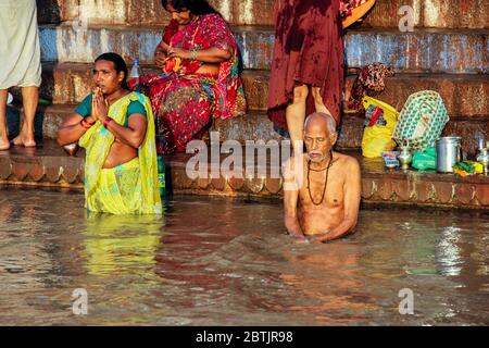 Indien, Varanasi - Bundesstaat Uttar Pradesh, 31. Juli 2013. Am Ufer des Ganges beten ein Mann und eine Frau im Morgengrauen. Stockfoto