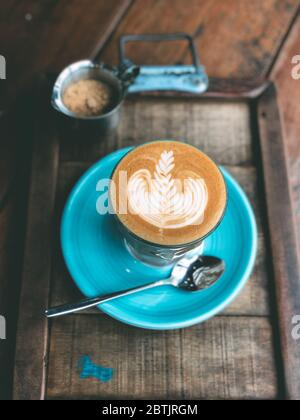 Tasse heißen Latte Art Kaffee auf Vintage Holztisch. Stockfoto