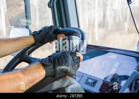 Kaukasischer männlicher Trucker, der während der Fahrt beide Hände am Lenkrad hält. Stockfoto