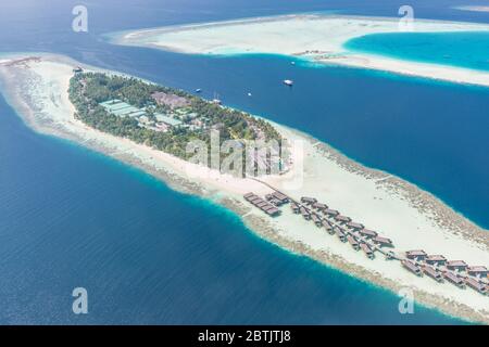 Luftaufnahme der Resort-Wasserbungalows. Luxuriöses tropisches Hotel über dem Korallenriff, das mit Atollen im Indischen Ozean verbunden ist. Atemberaubende Reiselandschaft Stockfoto