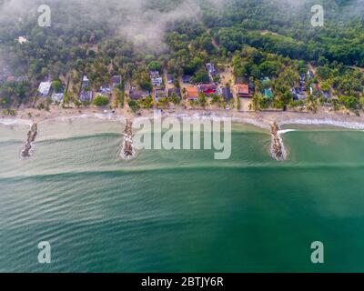 Luftaufnahme der paradiesischen Strände in der kolumbianischen Karibik, mit smaragdgrünem und blauem Wasser und pazifischen Wellen, die an die Küste ankommen Stockfoto