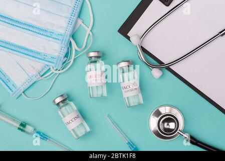 Volunteer Concept für die Prüfung von Impfstoffen gegen Coronavirus. Oben über der Ansicht von oben beschnittenes Foto von Impfstoff Fläschchen Masken Stethoskop Aufnahmen und Zwischenablage isoliert auf Stockfoto