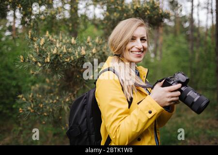 Attraktive Frau im Wald mit Digitalkamera Stockfoto
