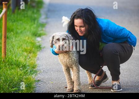Frau umarmt Hund (Lagotto romagnolo) Stockfoto
