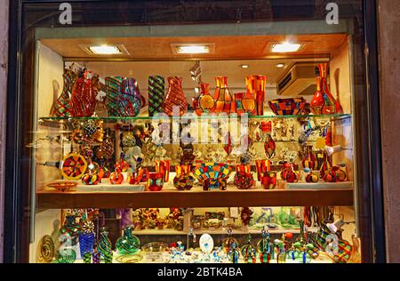 Buntes traditionelles Murano-Glas am Schaufenster des Souvenirshops an der Geschäftsstraße in der historischen Stadt Venedig, Italien Stockfoto