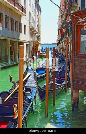 ;Alte Gebäude,geflieste Gondeln warten darauf gemietet zu werden und Brücke über einen kleinen Kanal in der Altstadt von Venedig,Italien,Juni 2016 Stockfoto