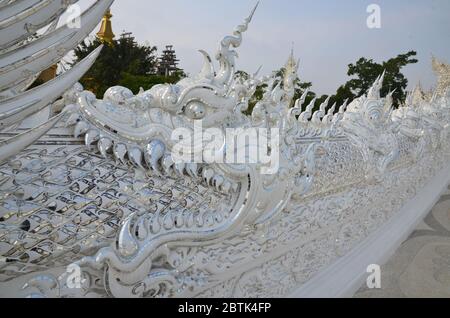 Ein riesiger Drache begrüßt die Besucher im Wat Rong Khun, dem schönen weißen Tempel in Chiang Rai Stockfoto