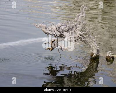 Der kleine Drache spuckt Wasser im kleinen Ententeich vor dem Wat Rong Khun, dem schönen weißen Tempel in Chiang Rai Stockfoto