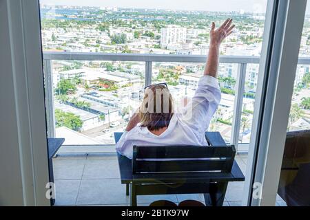 Miami Beach, Florida, Hispanic, Frau, gestikulend reden, Telefon, Smartphone, Balkon, FL200520017 Stockfoto