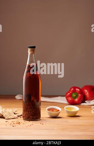 Flasche mit Öl, Chili, Paprika und Crackern Stockfoto