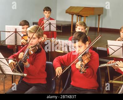 Jungs spielen Violinen und Flöten in Schulorchester, Surrey, England, Vereinigtes Königreich Stockfoto