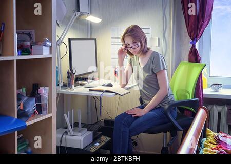 Junge Frau, die von zu Hause aus arbeitet. Porträt im Live-Interieur Stockfoto